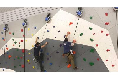 two people climbing on indoor climbing wall with auto belay