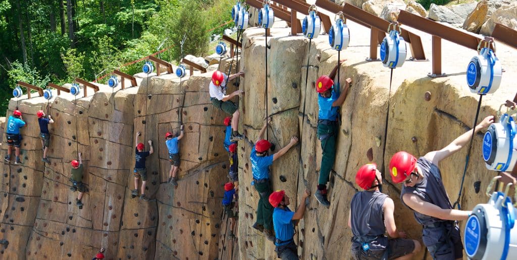 Large group climbing on outdoor wall TRUBLUE