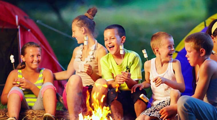 kids laughing and toasting marshmallows