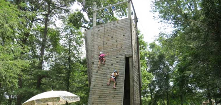kids on wooden rock climbing wall