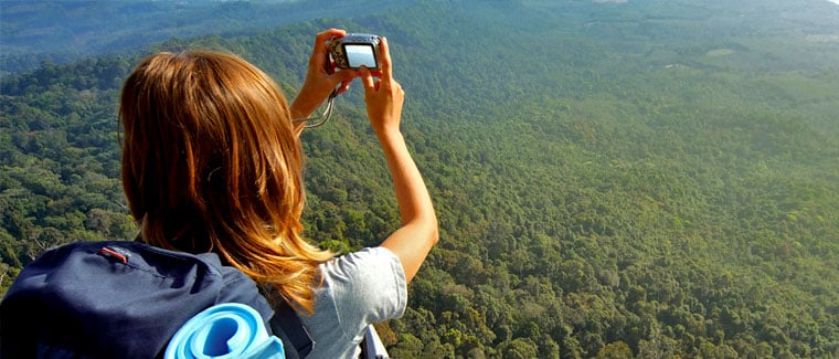 woman hiking taking picture with digital camera